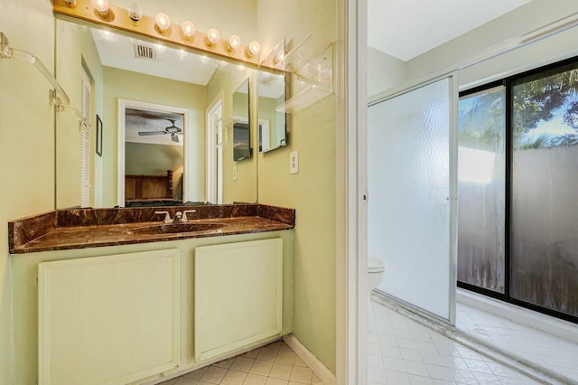 bathroom with tile patterned flooring, vanity, toilet, and ceiling fan