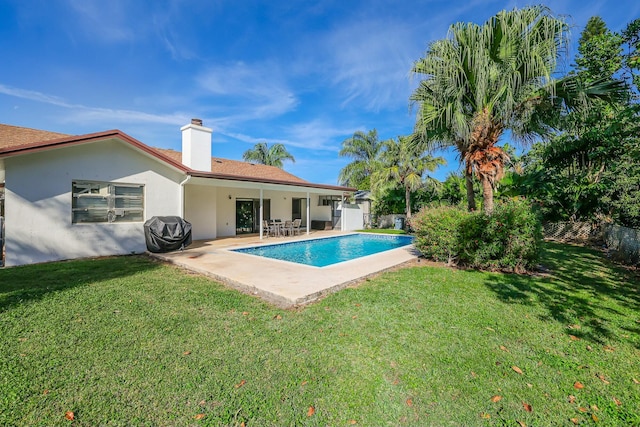 view of swimming pool featuring a yard, a patio area, and a grill