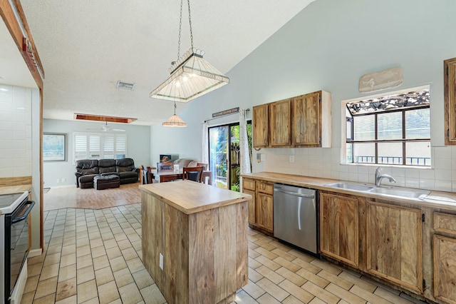 kitchen featuring stainless steel dishwasher, sink, decorative light fixtures, a kitchen island, and black / electric stove