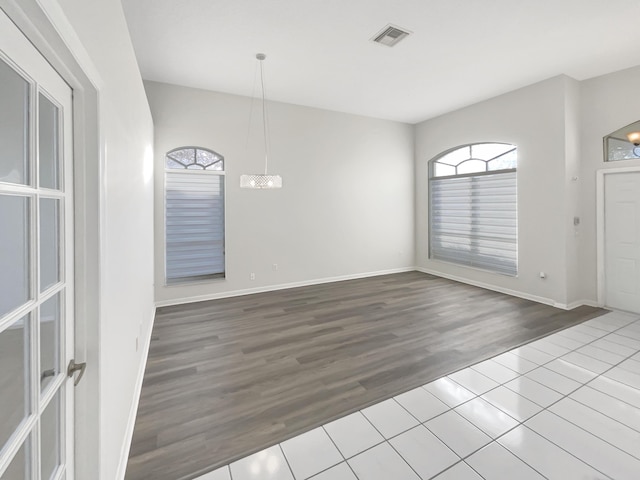 unfurnished room featuring tile patterned floors and a notable chandelier