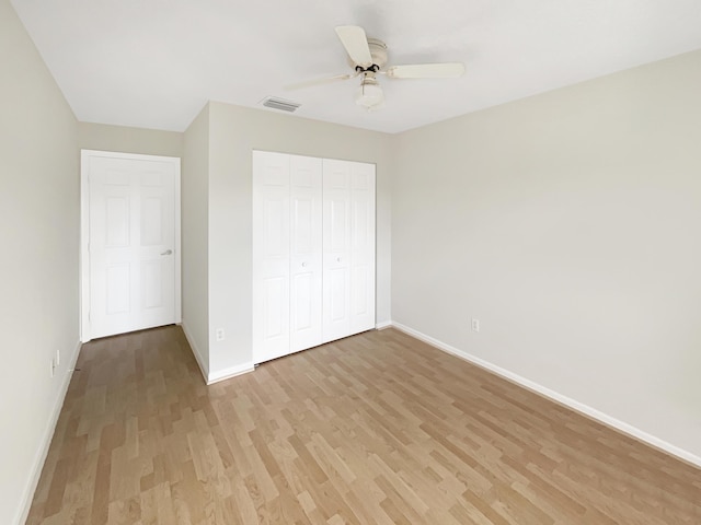 unfurnished bedroom featuring ceiling fan, a closet, and light hardwood / wood-style flooring