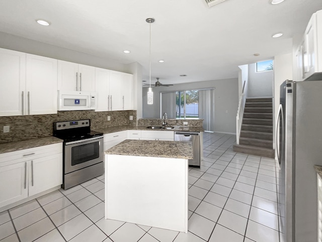 kitchen featuring kitchen peninsula, white cabinets, stainless steel appliances, and a kitchen island