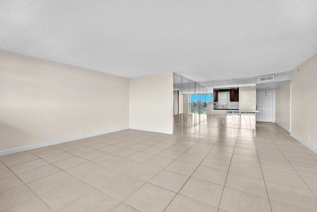 tiled spare room with a textured ceiling