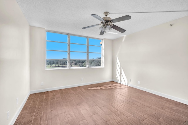 spare room with ceiling fan, hardwood / wood-style floors, and a textured ceiling