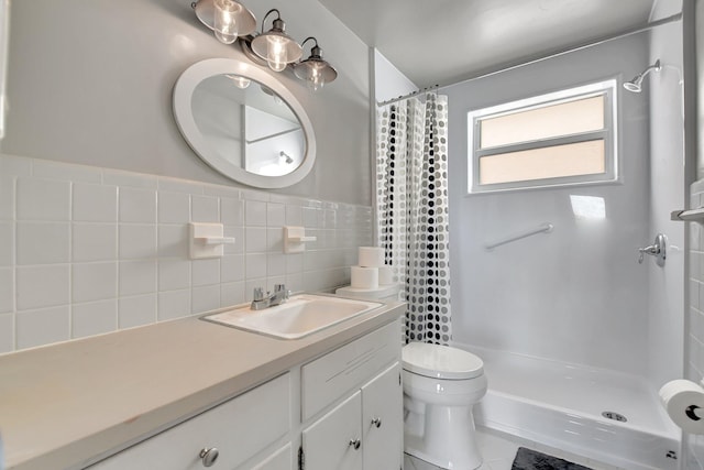 bathroom with a shower with curtain, vanity, toilet, and tile walls