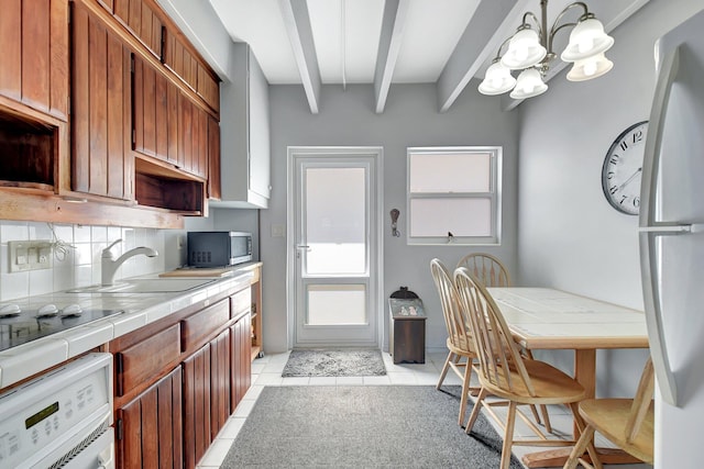 kitchen with beam ceiling, tile counters, sink, tasteful backsplash, and light tile patterned floors