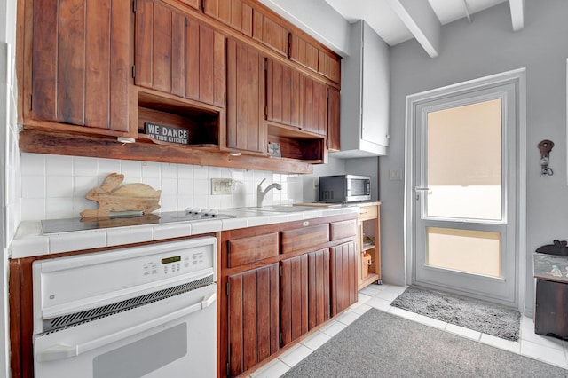 kitchen featuring tile counters, sink, white oven, decorative backsplash, and light tile patterned floors