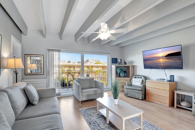 living room featuring ceiling fan, light hardwood / wood-style flooring, and beamed ceiling