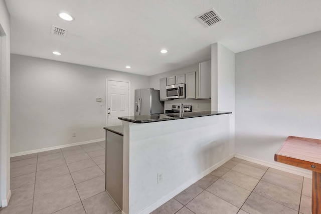 kitchen with kitchen peninsula, light tile patterned floors, stainless steel appliances, and sink