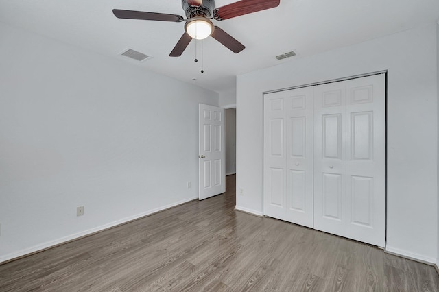 unfurnished bedroom with ceiling fan, light hardwood / wood-style flooring, and a closet