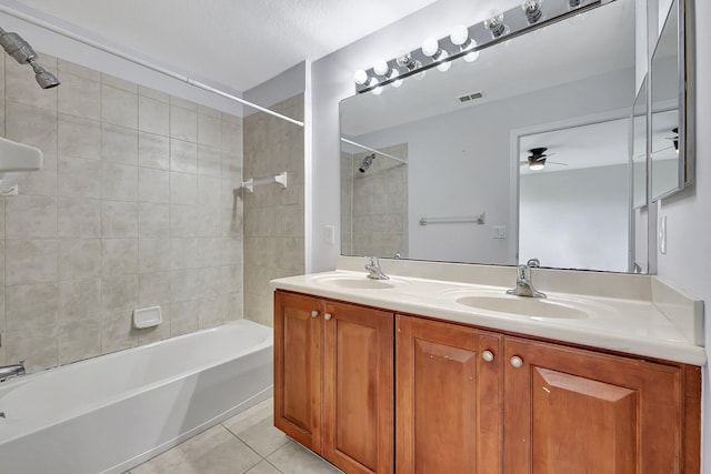 bathroom with tile patterned floors, ceiling fan, vanity, and tiled shower / bath combo