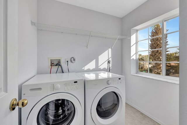 clothes washing area featuring washing machine and dryer and light tile patterned floors