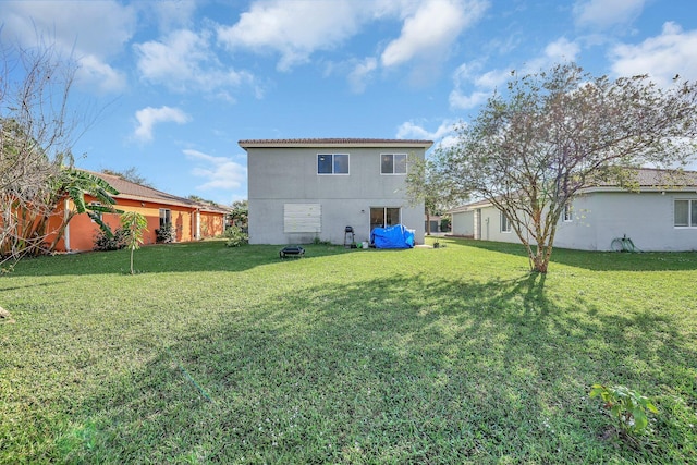 rear view of house featuring a yard