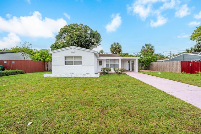 ranch-style home featuring a carport and a front lawn