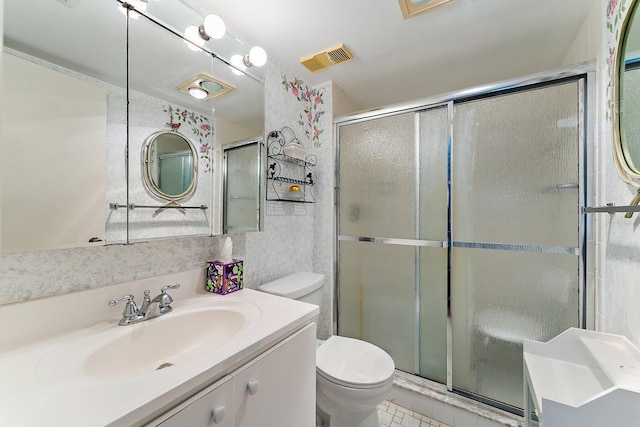 bathroom with tile patterned floors, vanity, toilet, and walk in shower