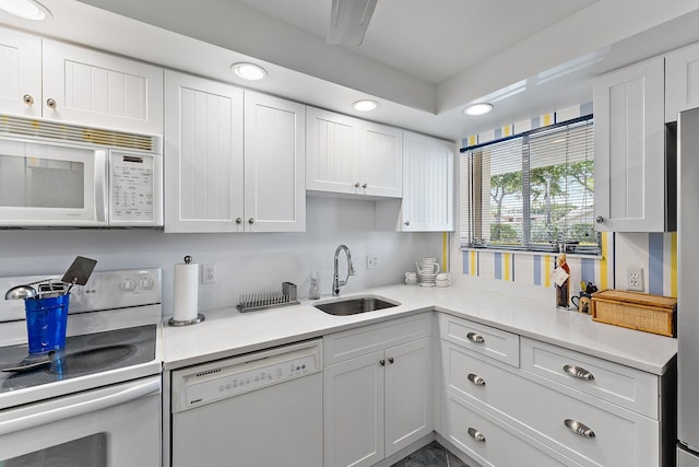 kitchen with white cabinetry, white appliances, and sink