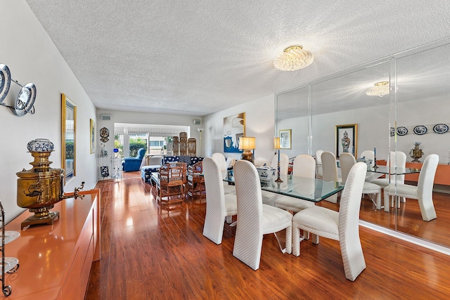 dining area featuring hardwood / wood-style flooring and a textured ceiling