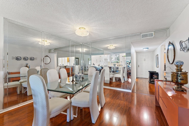 dining area with hardwood / wood-style flooring, a wood stove, and a textured ceiling