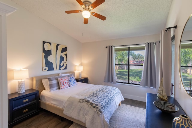 bedroom with a textured ceiling, ceiling fan, lofted ceiling, and dark wood-type flooring