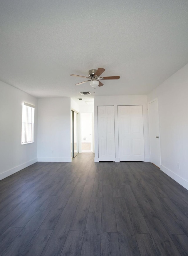 unfurnished room with a textured ceiling, dark hardwood / wood-style flooring, and ceiling fan