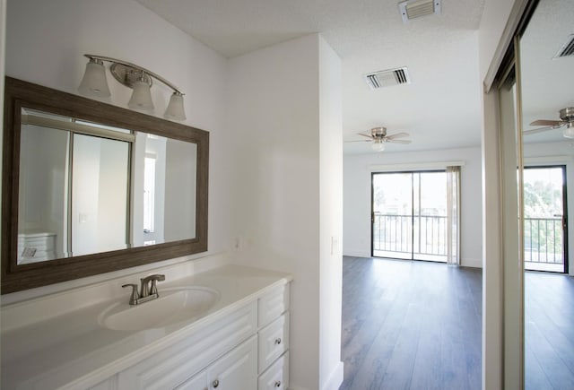 bathroom with hardwood / wood-style floors, vanity, a textured ceiling, and ceiling fan