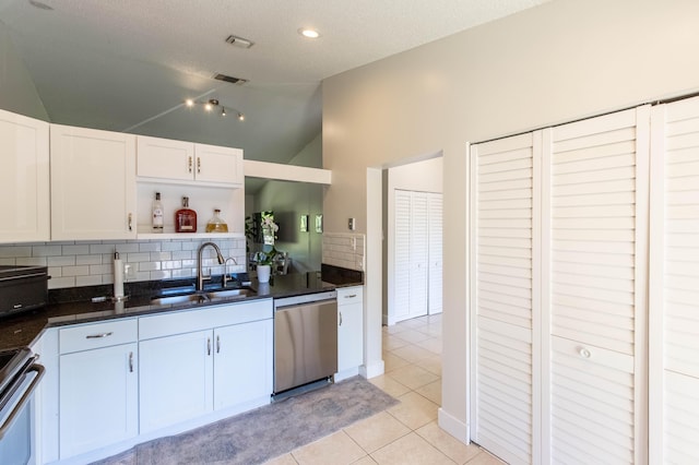 kitchen featuring sink, vaulted ceiling, decorative backsplash, white cabinetry, and stainless steel appliances