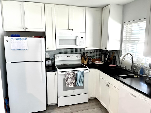 kitchen featuring white cabinetry, white appliances, and sink