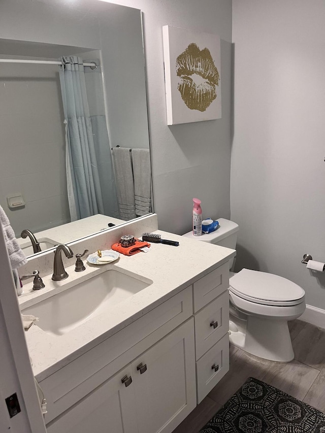 bathroom featuring a shower with shower curtain, vanity, and toilet