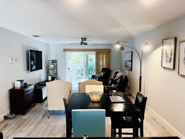 dining room with ceiling fan, a textured ceiling, and light wood-type flooring