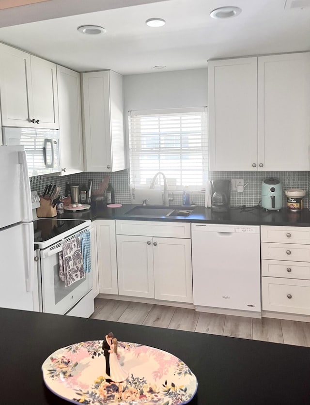 kitchen with white cabinets, white appliances, tasteful backsplash, and sink