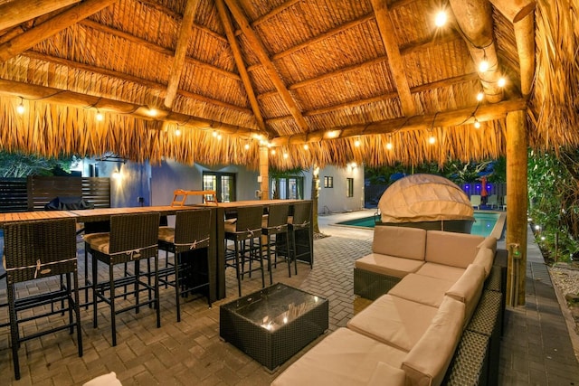 view of patio / terrace with a gazebo, an outdoor living space, a fenced in pool, and an outdoor bar