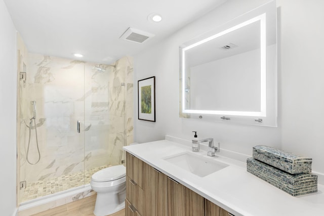 bathroom with toilet, vanity, and an enclosed shower