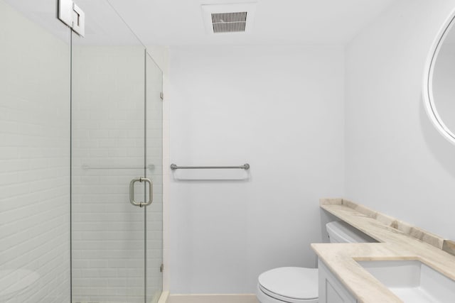 bathroom with toilet, vanity, and an enclosed shower