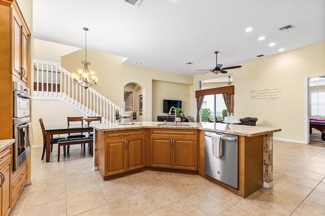 kitchen with a center island with sink, appliances with stainless steel finishes, sink, and pendant lighting