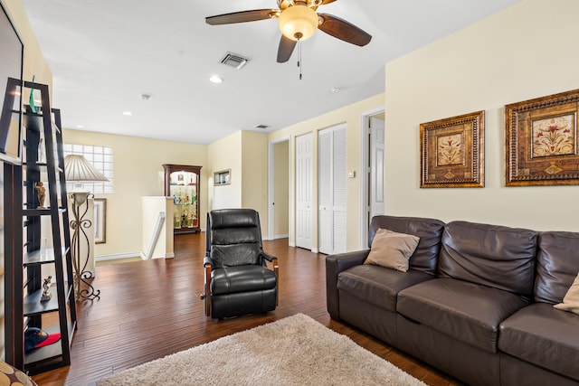 living room with ceiling fan and dark hardwood / wood-style flooring