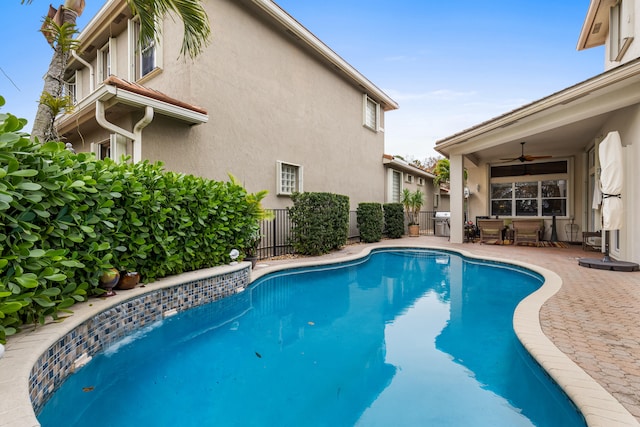 view of pool featuring ceiling fan, a patio, and area for grilling