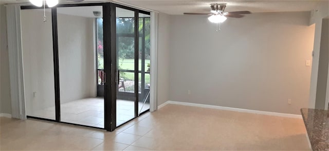 doorway to outside with ceiling fan, expansive windows, and light tile patterned floors