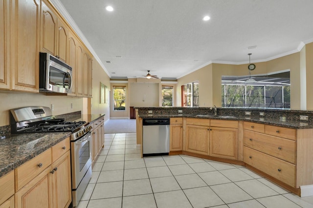 kitchen featuring stainless steel appliances, hanging light fixtures, dark stone countertops, and ceiling fan