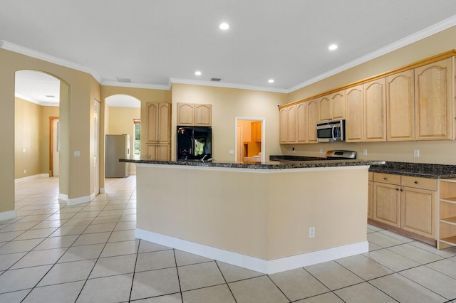 kitchen with light tile patterned floors, crown molding, appliances with stainless steel finishes, and dark stone counters