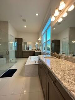 bathroom featuring vanity, tile patterned flooring, and plus walk in shower