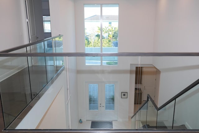 stairs with plenty of natural light and french doors