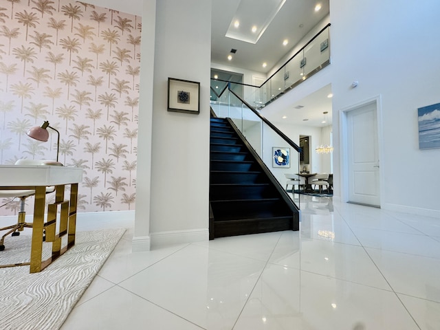 staircase with tile patterned flooring and a high ceiling