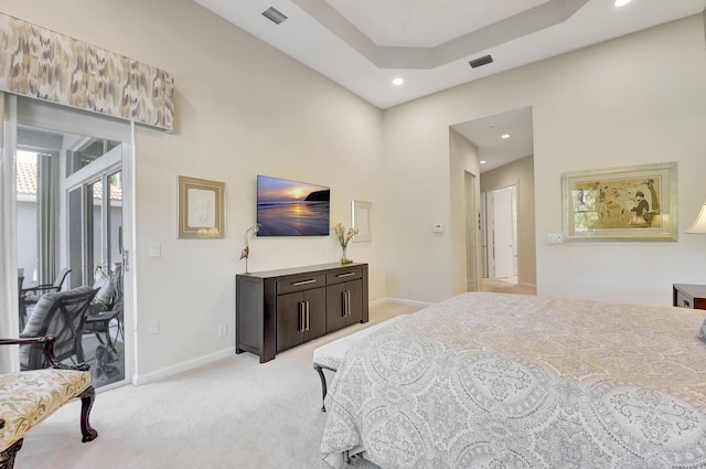 carpeted bedroom featuring access to outside and a raised ceiling