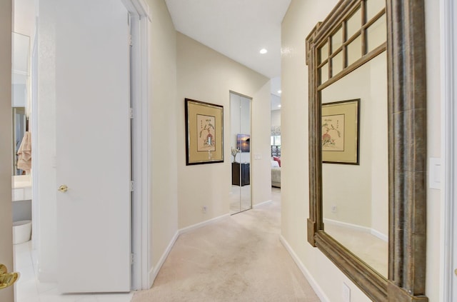 corridor featuring light colored carpet