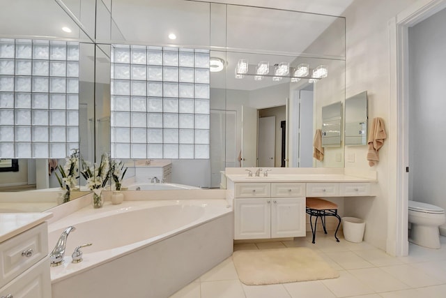 bathroom with tile patterned floors, a bathing tub, vanity, and toilet