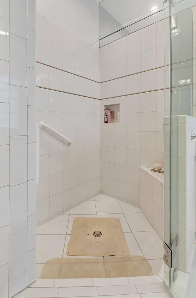 bathroom with tiled shower and tile patterned floors