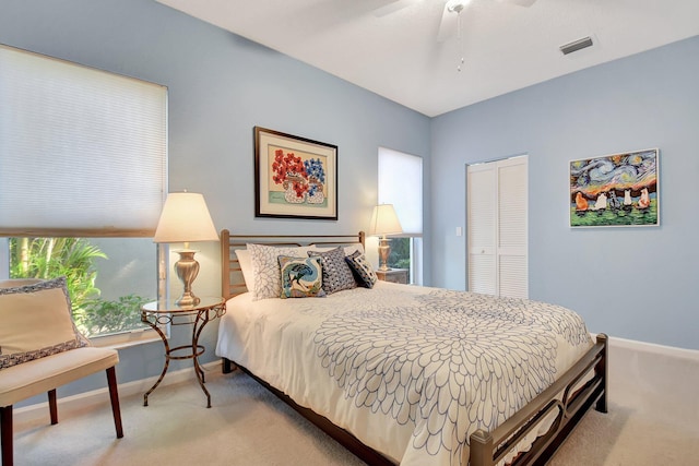 carpeted bedroom featuring ceiling fan and a closet