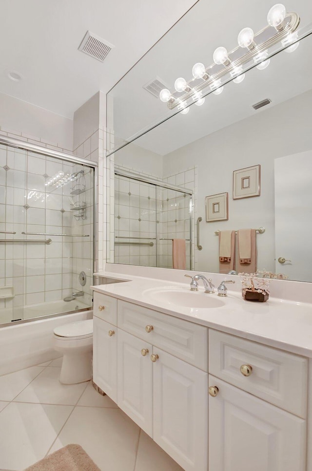 full bathroom with tile patterned flooring, vanity, bath / shower combo with glass door, and toilet