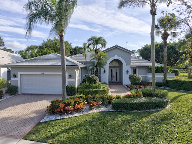 single story home with a garage, decorative driveway, and stucco siding