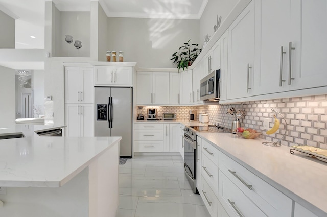 kitchen with light stone countertops, ornamental molding, appliances with stainless steel finishes, tasteful backsplash, and white cabinetry